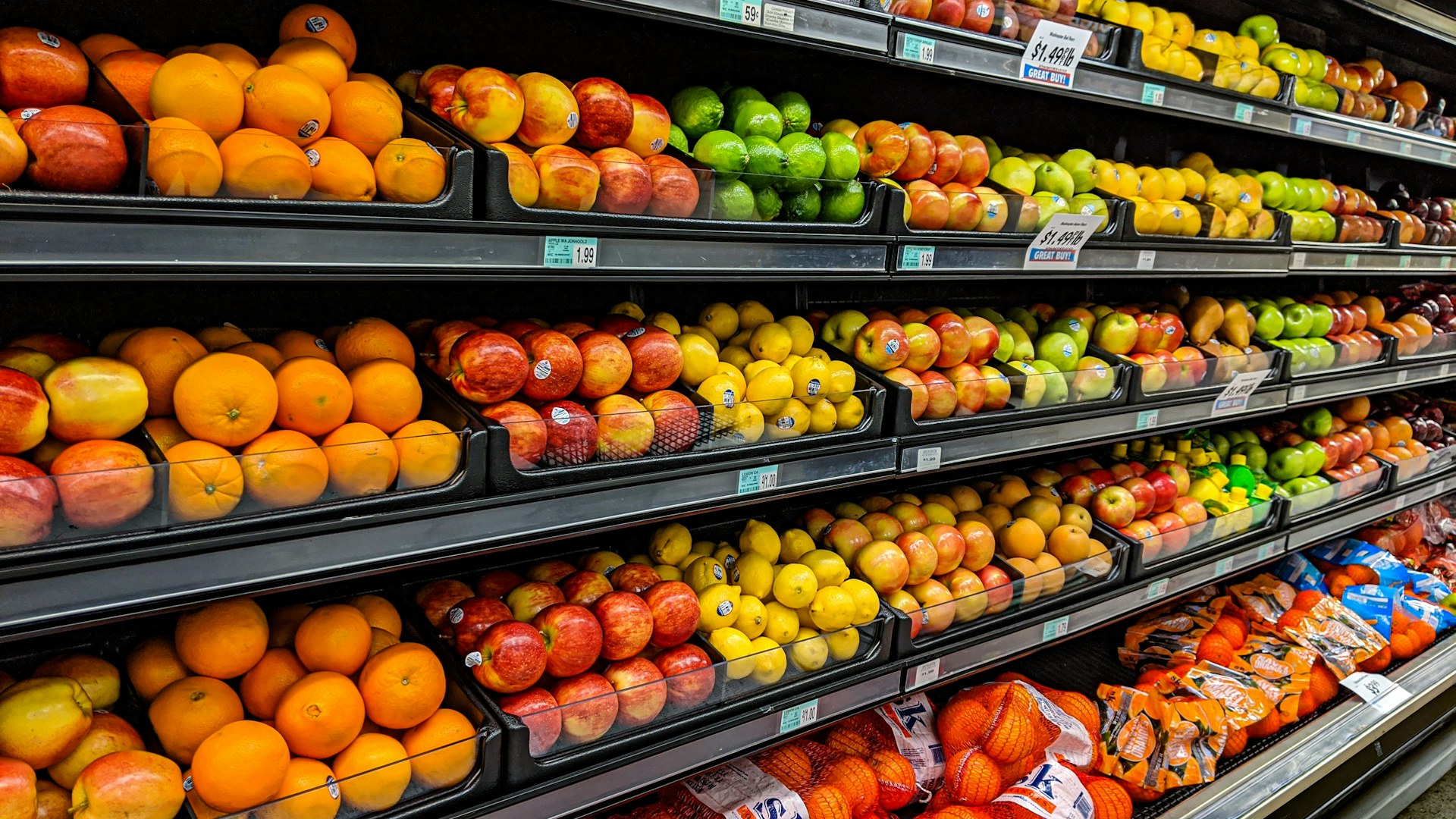 Fresh oranges, apples and lemons on grocery shelves